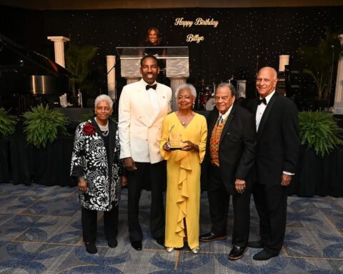 Billye Aaron in yellow holding the Phoenix Award, flanked by Mayor Andre Dickens and Ambassador Andrew Young at her 90th birthday celebration at the Hyatt Regency Atlanta. Photo: City of Atlanta.